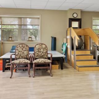 A well-equipped physical therapy room featuring exercise steps and chairs.
