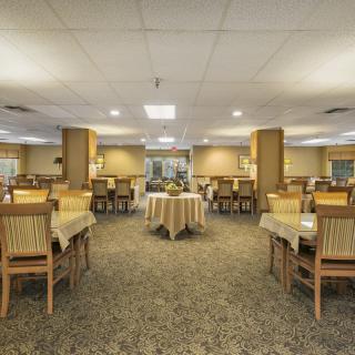 Interior view of a spacious restaurant dining area with neatly arranged tables and chairs.