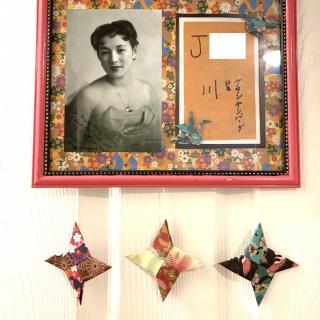 A decorative wall display featuring a framed black and white photograph alongside colorful origami stars.