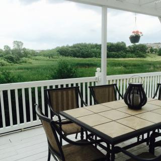 A peaceful patio with a table and chairs overlooking lush greenery.