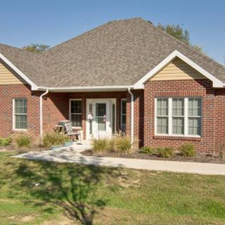 A suburban brick house with a well-maintained front yard and driveway.