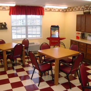 A cozy dining area with checkered flooring and a popcorn machine.
