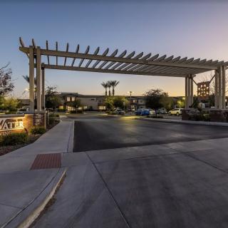 A gated entrance with surrounding landscaping and palm trees at dusk.