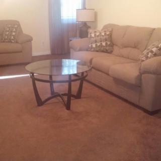 Cozy living room with sofas and a glass coffee table.