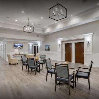 A modern interior seating area with tables, chairs, and decorative lighting.