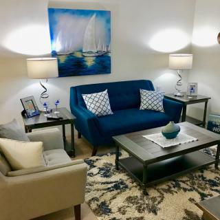 A cozy living room with a blue sofa, stylish artwork, and elegant lighting.