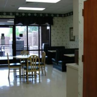 Empty restaurant dining area with chairs and tables near large windows.