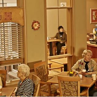 A cozy cafe with seniors enjoying drinks at tables, engaging in conversation.