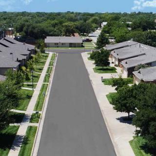 Aerial view of a suburban neighborhood with neatly arranged houses and tree-lined streets.