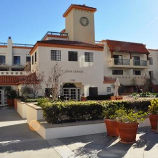 A picturesque building featuring a clock tower and vibrant greenery in its surroundings.