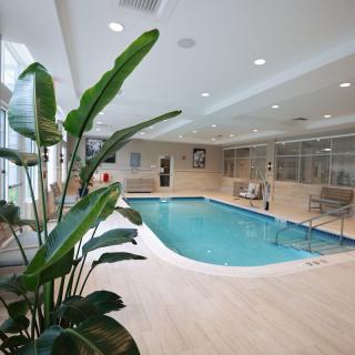 A luxurious indoor pool surrounded by modern amenities and greenery, perfect for relaxation.