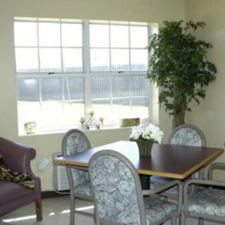 A cozy dining area with a table, chairs, and a large window letting in natural light.