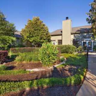A well-maintained garden with lush greenery in front of a residential building.