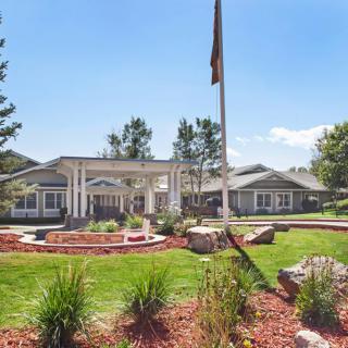 A well-maintained building with a landscaped lawn and clear blue sky.