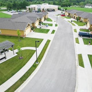 Aerial view of a suburban residential neighborhood with neatly arranged houses and green lawns.