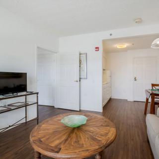 A modern living room with a wooden coffee table, flat-screen TV, and cozy seating area.