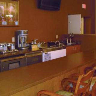 An empty bar with a counter and seating area.