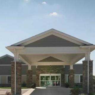 A building entrance with a large canopy and stone pillars.