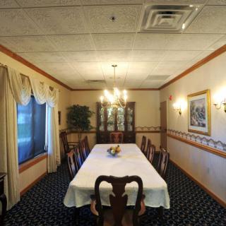 A formal dining room with a long table, elegant chairs, and a chandelier.