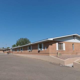 A brick motel building under a clear blue sky.
