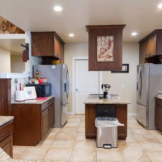 A modern kitchen featuring stainless steel appliances, wooden cabinets, and a spacious countertop.