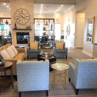 A modern living room with stylish furniture and a cozy seating area around a fireplace.