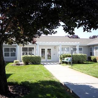 A single-story house with a well-maintained lawn and pathway leading to the entrance.