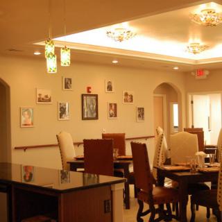 A cozy dining area with arranged tables, chairs, and decorative lighting.
