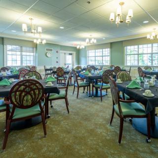 Elegant dining area with neatly arranged tables and classic chandeliers.