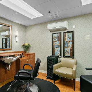A cozy salon interior featuring a haircut station, comfortable seating, and an elegant decor.