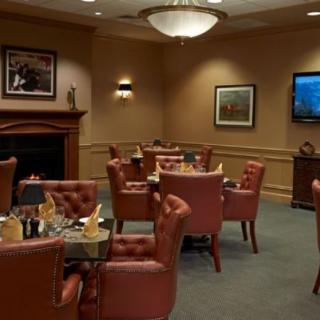 An elegant dining room with leather chairs and neatly set tables.