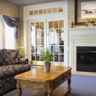 A cozy living room with a floral sofa, wooden coffee table, and fireplace.