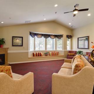 A cozy living room with sofas, a fireplace, and large windows.