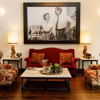 A well-decorated living room with a red sofa, artwork on the wall, and elegant lighting.