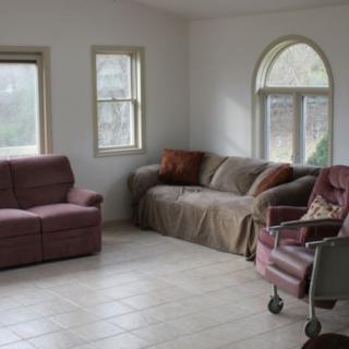 A cozy living room with sofas and a window providing natural light.