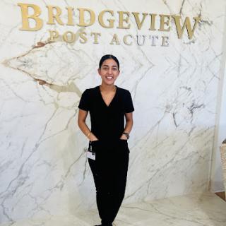 A healthcare professional standing proudly in the Bridgeview Post Acute facility.