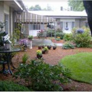 A well-maintained garden with lush greenery and a cozy patio area.