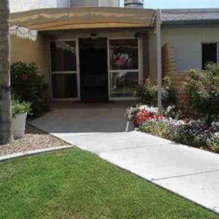 Entrance to a building with a pathway and well-maintained landscaping.