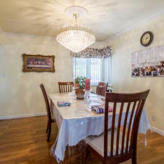 A dining room featuring a chandelier, table with chairs, and decorative elements.