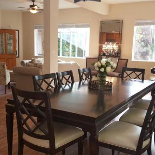 A beautifully decorated dining area with a dark wood table and stylish chairs, leading into a cozy living space.