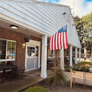 A welcoming community center featuring an American flag and outdoor seating.
