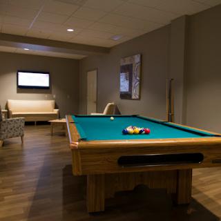 A cozy recreation room featuring a pool table and comfortable seating.