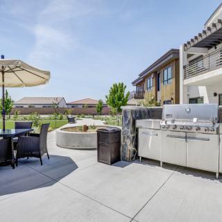 A modern outdoor patio with a grill and seating area under a sunny sky.