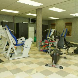 A gym room equipped with various exercise machines and weights.