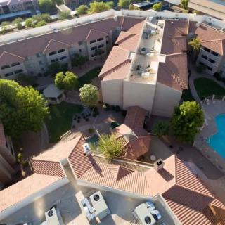 Aerial view of a residential complex with a pool and landscaped surroundings.