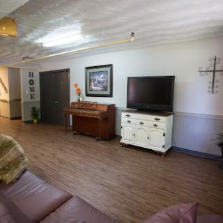 A cozy living room featuring a television, a piano, and tasteful decor.