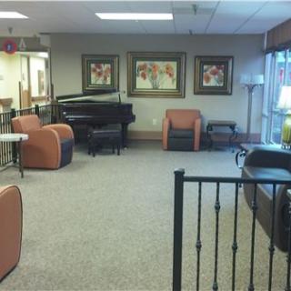 A lobby featuring seating arrangements and a piano.