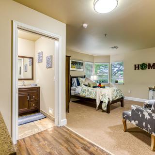 A cozy bedroom with an adjoining bathroom, featuring modern interior design and homey decor.
