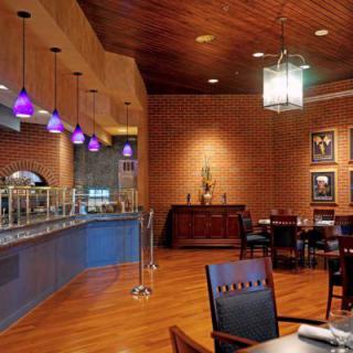 A cozy restaurant interior featuring a buffet setup with warm lighting and wooden furnishings.