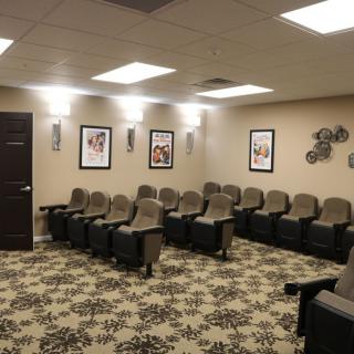 A cozy home theater room with comfortable seating and wall decorations.